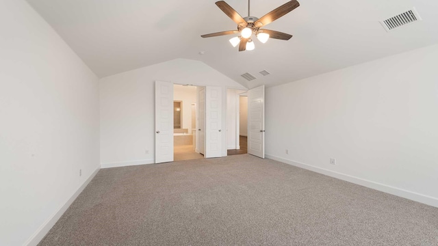 unfurnished bedroom with carpet, connected bathroom, vaulted ceiling, and ceiling fan