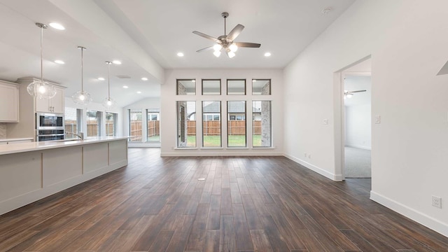 unfurnished living room featuring dark hardwood / wood-style flooring, ceiling fan, and sink