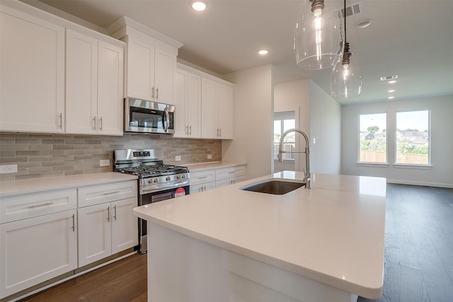 kitchen featuring sink, white cabinetry, hanging light fixtures, an island with sink, and stainless steel appliances