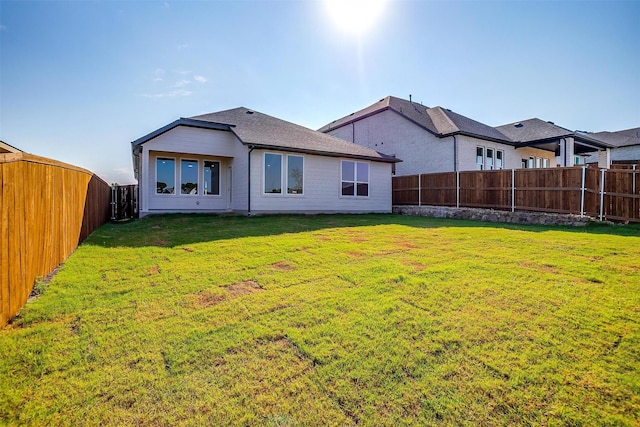 rear view of house featuring a lawn