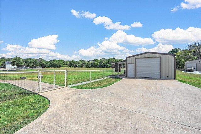 garage with a rural view and a yard