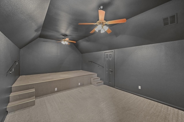 bonus room featuring carpet, a textured ceiling, ceiling fan, and lofted ceiling