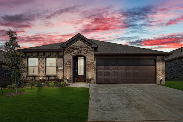 view of front of house featuring a garage and a yard