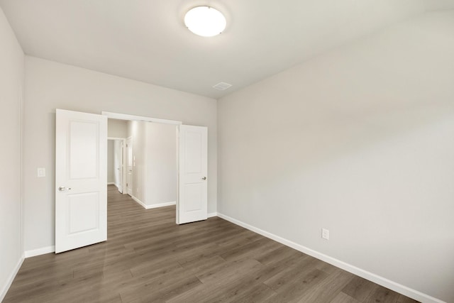 unfurnished bedroom with dark hardwood / wood-style flooring