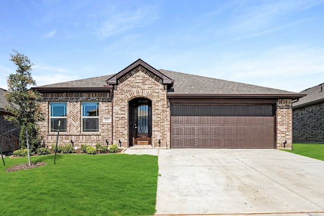 view of front of property with a garage and a front lawn