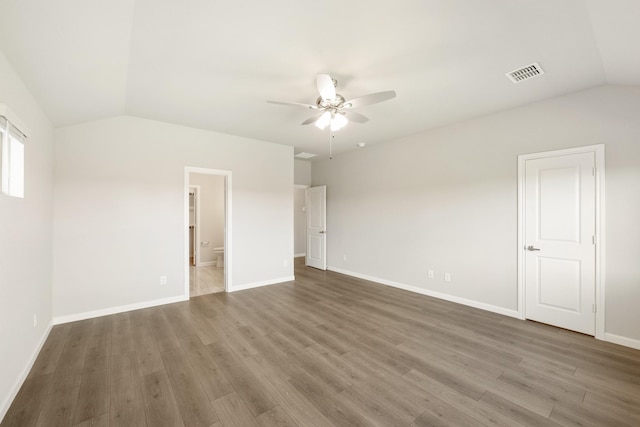 empty room featuring dark hardwood / wood-style flooring, vaulted ceiling, and ceiling fan