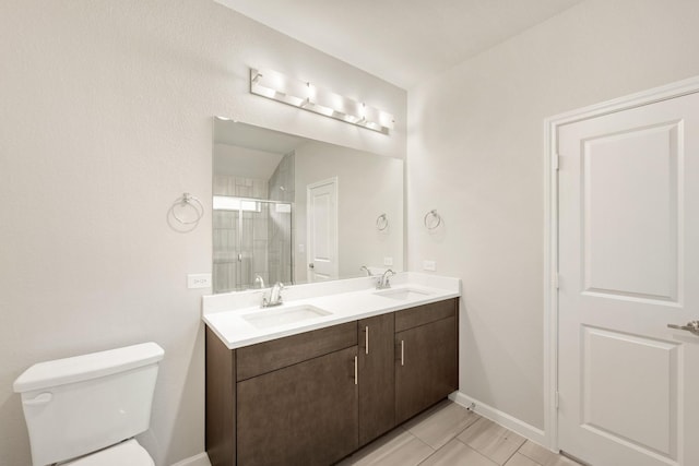 bathroom featuring tile patterned floors, vanity, toilet, and a shower with door