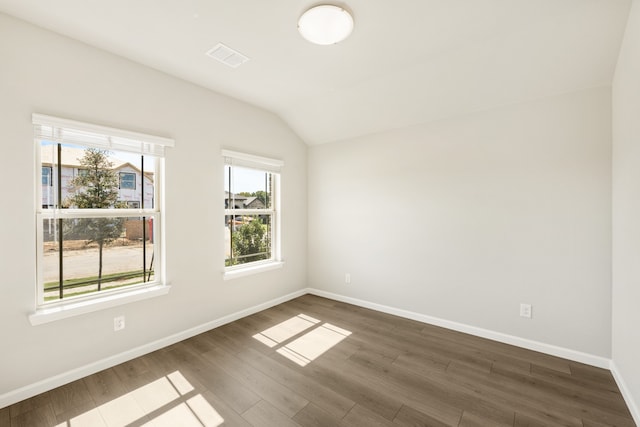 unfurnished room featuring dark wood-type flooring and lofted ceiling