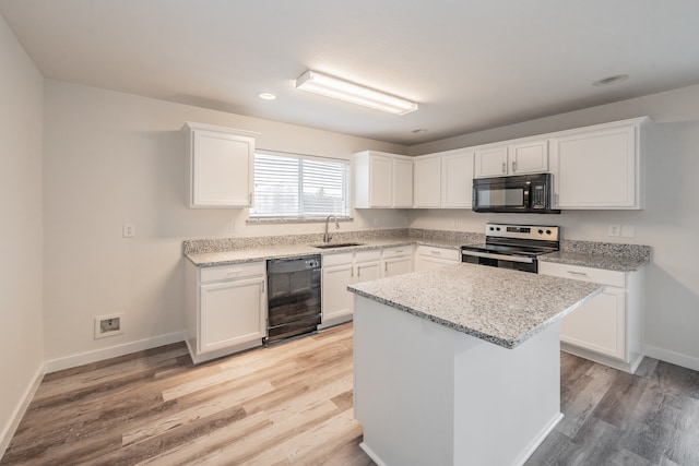 kitchen featuring sink, black appliances, light hardwood / wood-style floors, and white cabinets