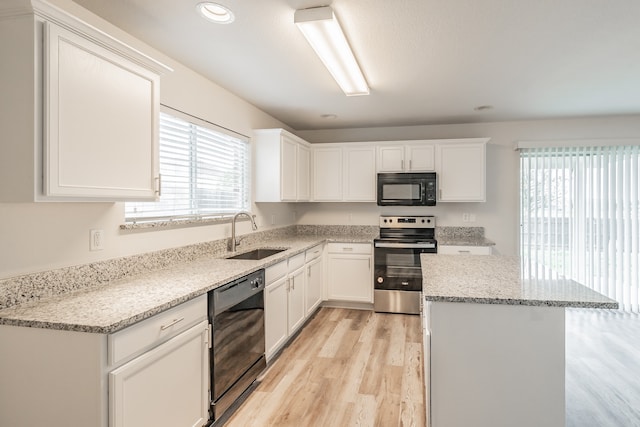 kitchen featuring white cabinets, black appliances, light hardwood / wood-style flooring, and sink