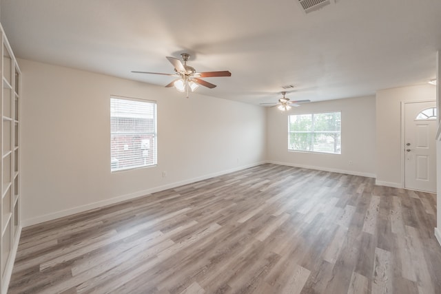 spare room with ceiling fan and light wood-type flooring