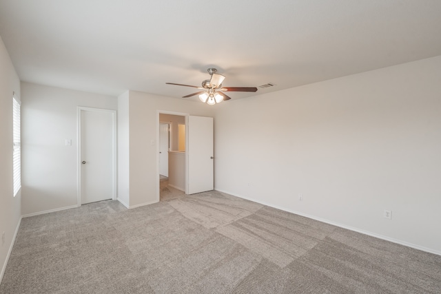 unfurnished bedroom featuring light carpet, a closet, and ceiling fan