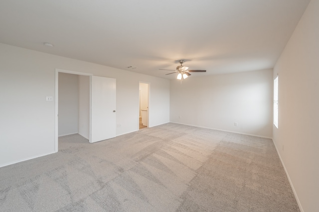 spare room featuring light colored carpet and ceiling fan