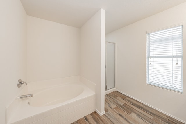 bathroom with plus walk in shower and hardwood / wood-style floors