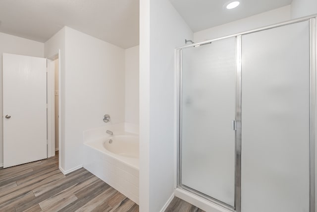 bathroom with shower with separate bathtub and hardwood / wood-style floors