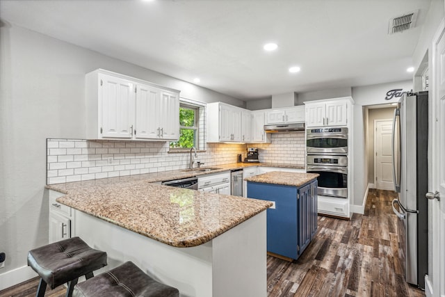 kitchen featuring white cabinets, a center island, sink, and appliances with stainless steel finishes