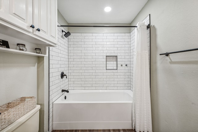 bathroom featuring wood-type flooring, shower / tub combo, and toilet