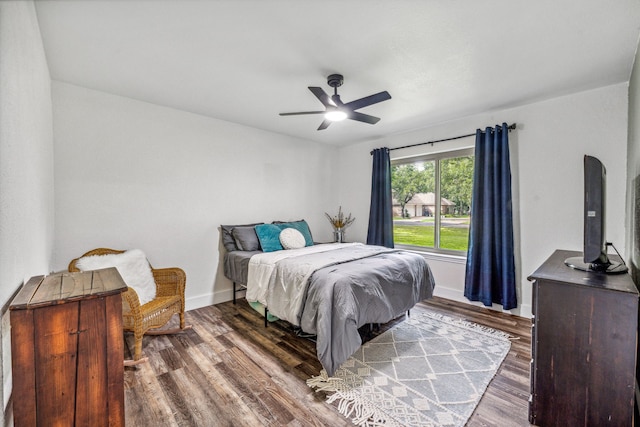 bedroom with dark hardwood / wood-style floors and ceiling fan