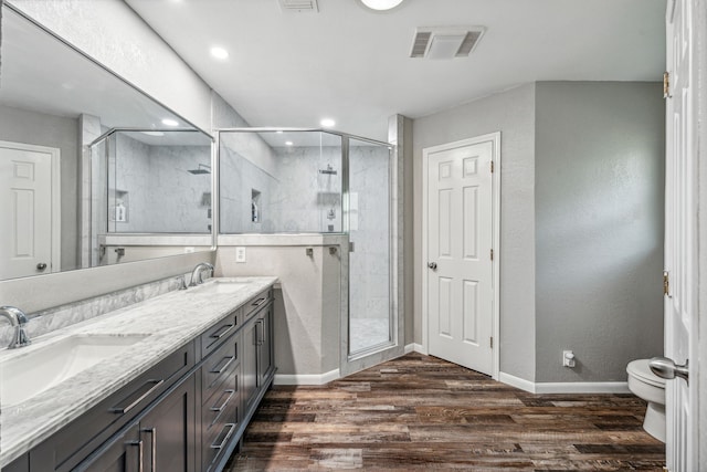 bathroom with wood-type flooring, vanity, and a shower with door