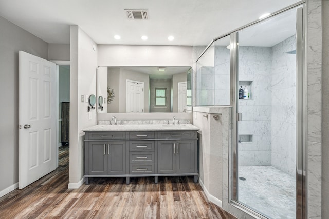 bathroom with vanity, a shower with shower door, and hardwood / wood-style flooring