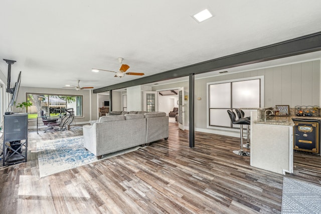 living room featuring ceiling fan and dark wood-type flooring