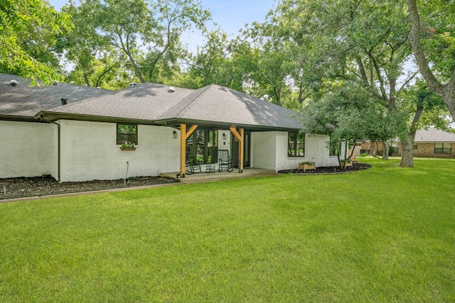 rear view of house with a yard and a patio