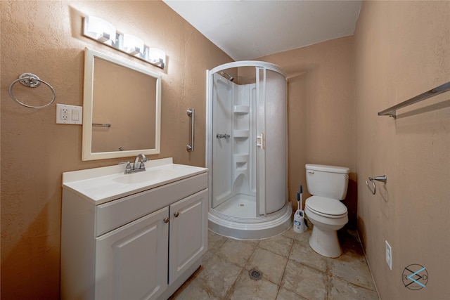 bathroom with a shower with shower door, vanity, tile patterned floors, and toilet