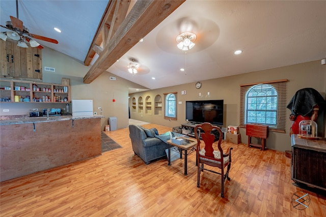 living room featuring lofted ceiling with beams, ceiling fan, and light wood-type flooring