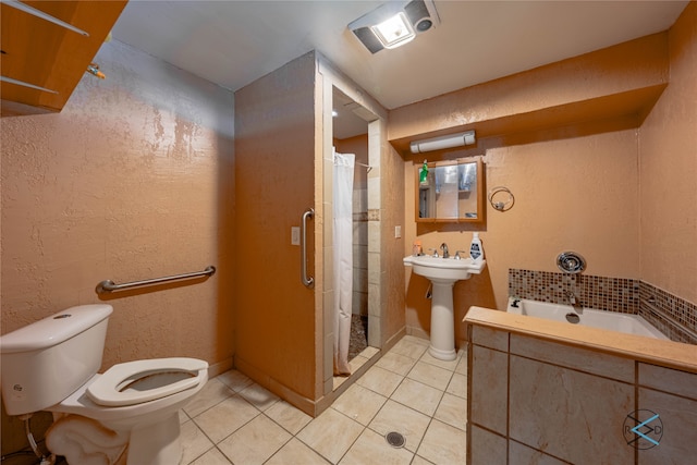 full bathroom with shower with separate bathtub, sink, toilet, and tile patterned floors