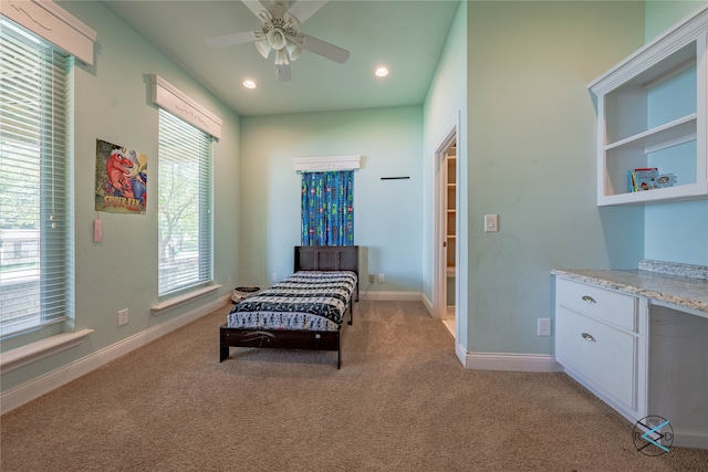 living area featuring light carpet and ceiling fan