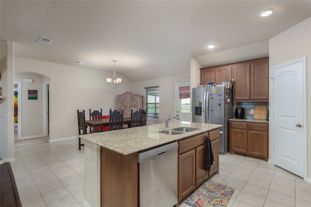 kitchen with sink, decorative light fixtures, a center island with sink, stainless steel appliances, and backsplash