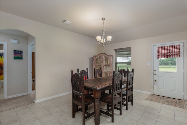 tiled dining area featuring a chandelier