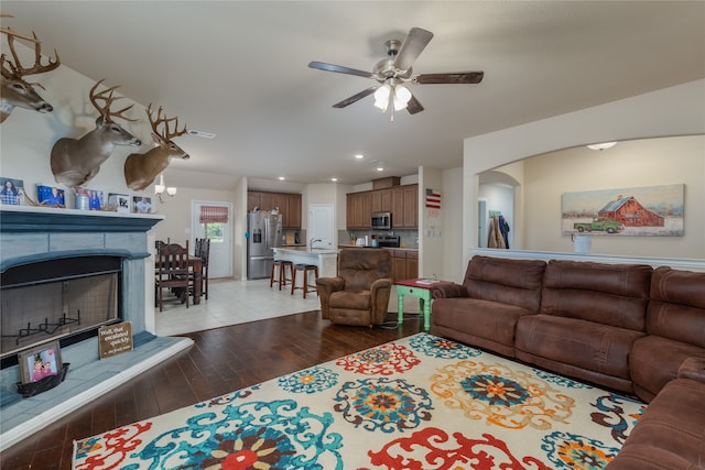 living room with ceiling fan and dark hardwood / wood-style flooring