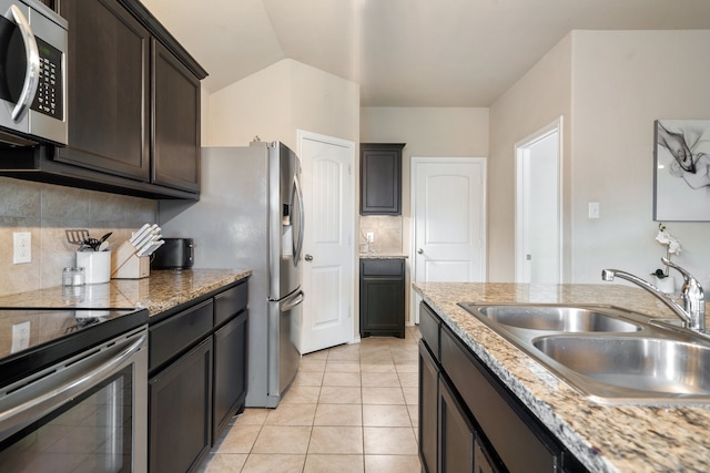 kitchen featuring sink, stainless steel appliances, light tile patterned floors, and backsplash