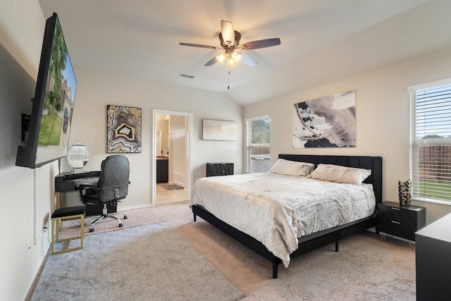 bedroom featuring ceiling fan, multiple windows, light colored carpet, and ensuite bath