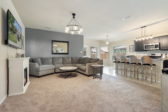 carpeted living room featuring a notable chandelier