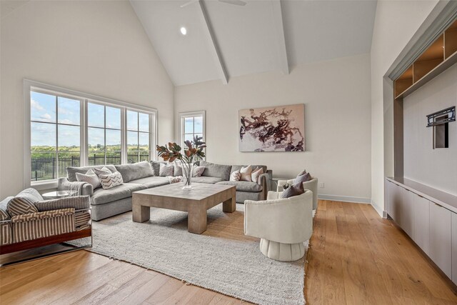 living room featuring high vaulted ceiling and light wood-type flooring