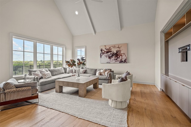 living room featuring high vaulted ceiling and light wood-type flooring