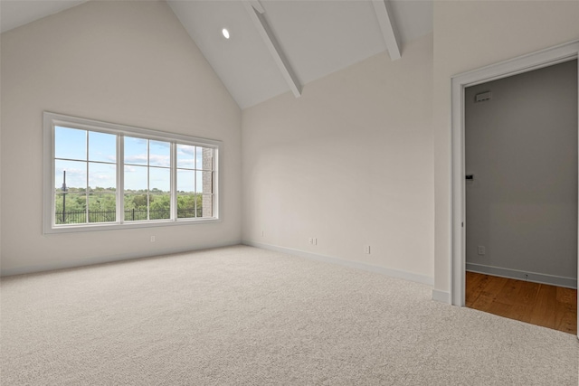 carpeted spare room featuring beam ceiling and high vaulted ceiling