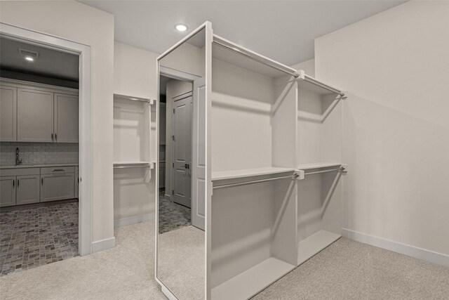 spacious closet with sink and light tile patterned floors