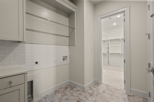 clothes washing area featuring electric dryer hookup, hookup for a washing machine, and light tile patterned floors