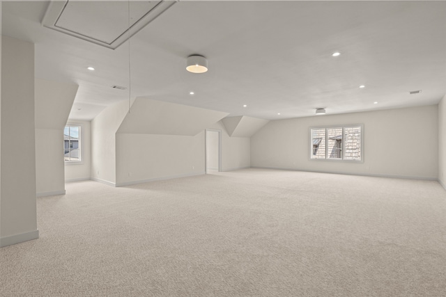 bonus room featuring light carpet, a wealth of natural light, and lofted ceiling