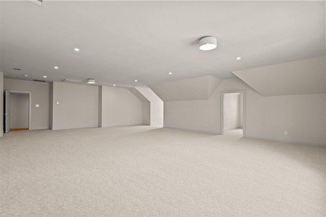 additional living space with light carpet and vaulted ceiling