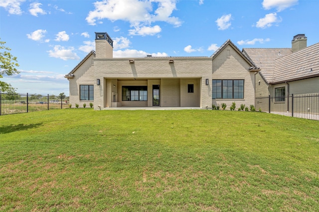 rear view of property featuring a patio and a yard