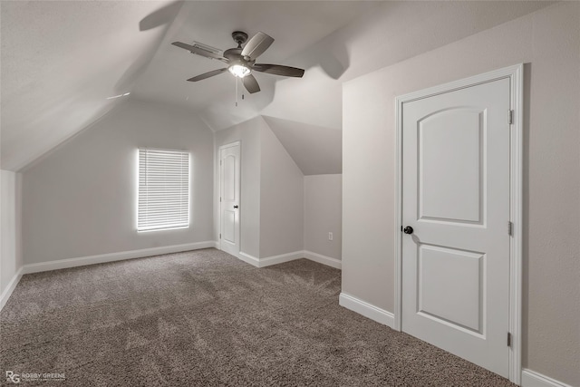 additional living space featuring dark carpet, vaulted ceiling, and ceiling fan