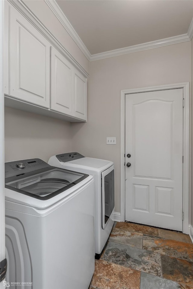 clothes washing area with cabinets, washing machine and dryer, and ornamental molding