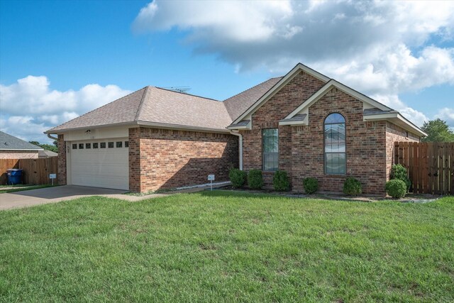 view of front of property with a garage and a front lawn