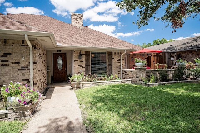 view of exterior entry with a lawn