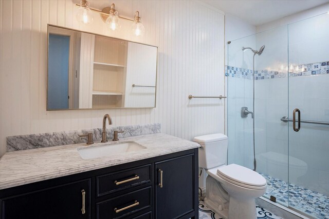 bathroom with a shower with door, vanity, and toilet