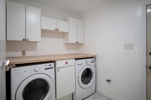 laundry area featuring washer and dryer and cabinets